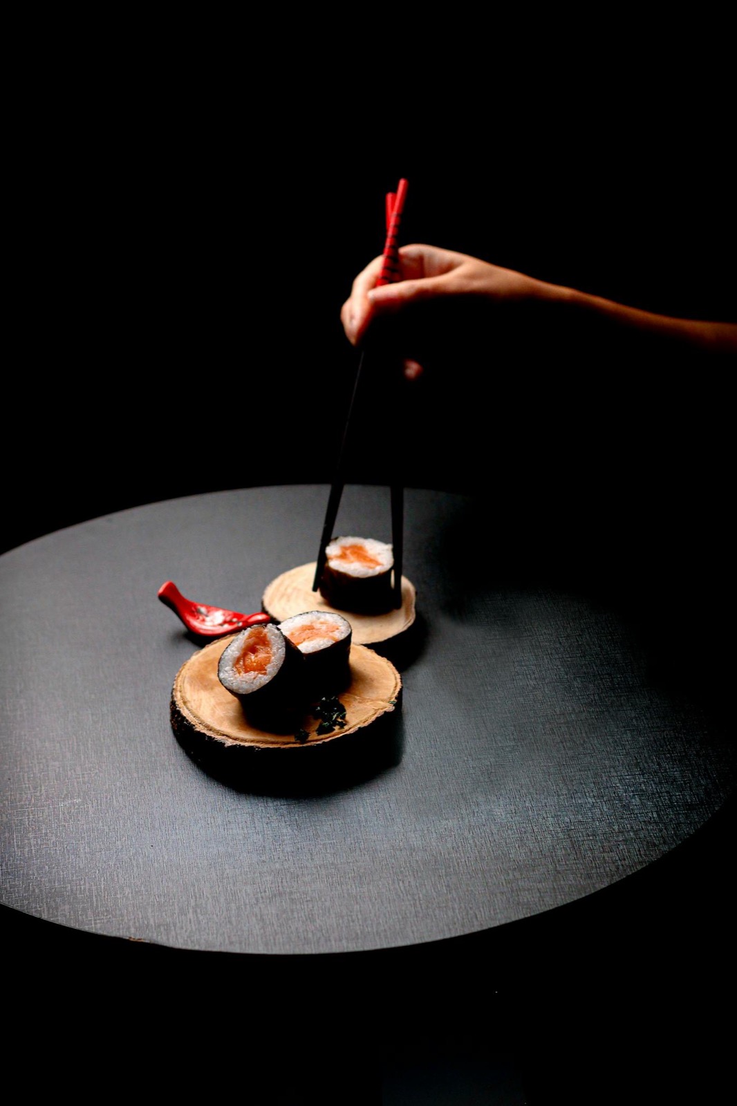 Sushi maki saumon — restaurant japonais La Jetée à Juan-les-Pins, disque de bois et baguettes laquées rouges